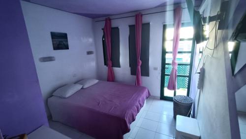 a small bedroom with a bed and a window at Dunaflor Gemelo 1 in San Bartolomé