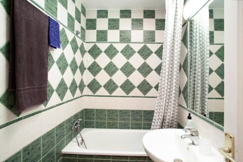 a bathroom with a white tub and a sink at Dunaflor Gemelo 1 in San Bartolomé