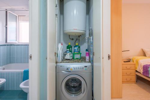 a bathroom with a washing machine in a room at Apartamento Merida in Alcanar