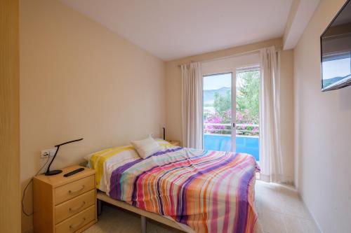 a bedroom with a bed and a window with a view at Apartamento Merida in Alcanar