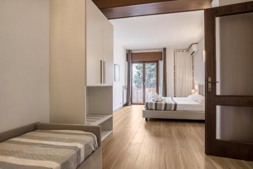 a bedroom with two beds and a door with a window at Appartamento Fiocco in Malcesine
