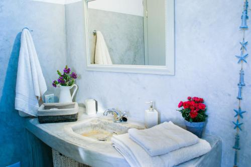 a bathroom with a sink with towels and a mirror at House with private pool in Naousa