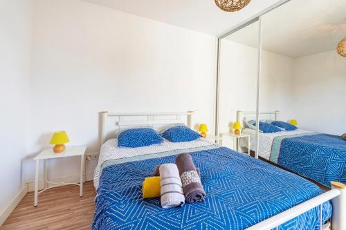 a bedroom with two beds with a mirror on it at Imarena, Elegance et Vue Port in Capbreton