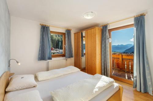 a bedroom with a bed and a large window at Burgerhof in Gsies