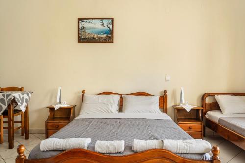 a bedroom with a bed and two chairs and a table at Daratos studio 4 in Kefallonia