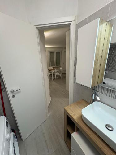 a bathroom with a white sink and a mirror at Appartamenti Flora in Castelsardo