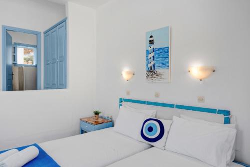 a white bedroom with a bed with a target on it at Pico Bello Patmos 28 in Patmos