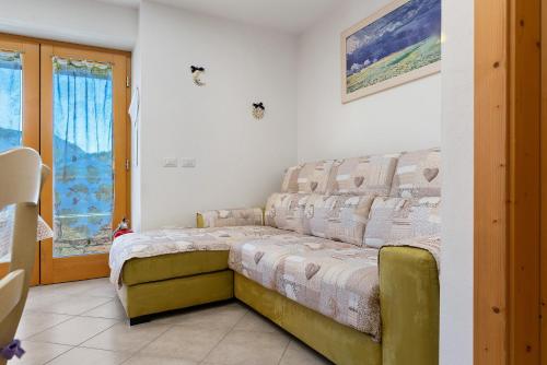 a bedroom with a couch in a room at Appartamento Lory in Cavedago