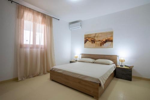 a bedroom with a large bed and a window at Villa Giovanna in Sorso