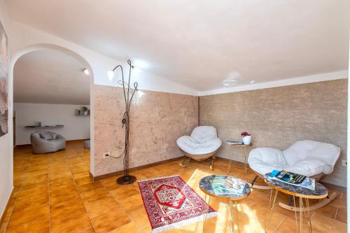 a living room with two white chairs and a table at Villa Giovanna in Sorso