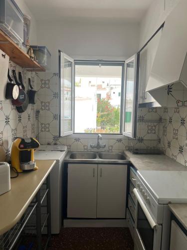 a small kitchen with a sink and a window at Una casa sulla spiaggia in Es Grau