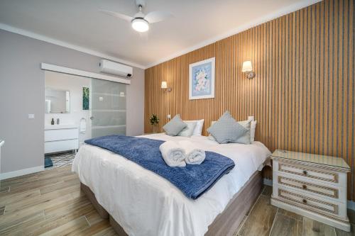 a bedroom with a large bed with towels on it at Orange Blossom Grove in São Bartolomeu de Messines