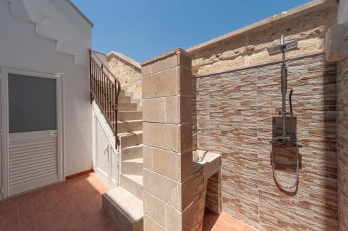 a bathroom with a shower in a brick wall at Rosy Maison in Squinzano