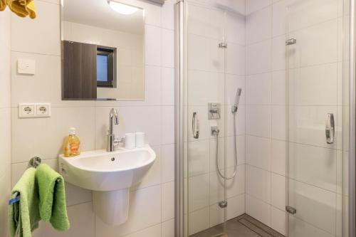 a white bathroom with a sink and a shower at Ferienwohnung Lago in Konstanz