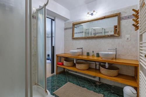 a bathroom with two sinks and a mirror at Maison dans la Drôme Piscine privée in Montélimar