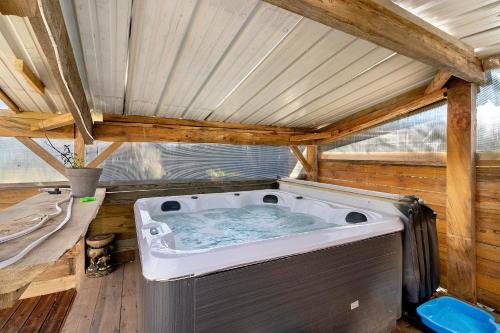 a jacuzzi tub in the middle of a house at Chalet de Ferme - Spa - Gironde in Les Églisottes-et-Chalaures