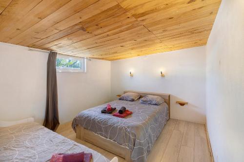 a bedroom with a bed with two shoes on it at Chalet de Ferme - Spa - Gironde in Les Églisottes-et-Chalaures