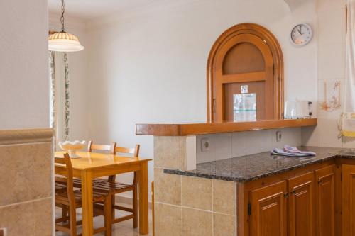 a kitchen with a counter and a table and a dining room at Villa Loes in Menorca