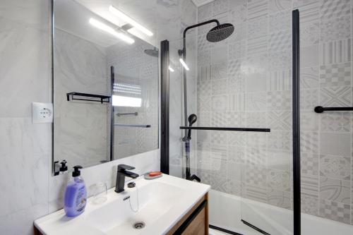 a white bathroom with a sink and a shower at Barrinha Beach in Esmoriz