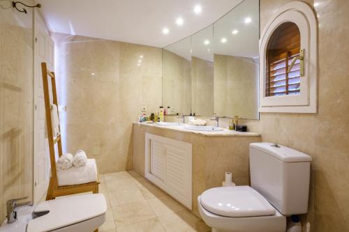 a bathroom with a toilet and a sink and a mirror at Can Bernat in Can Furnet