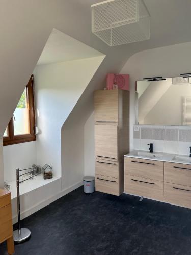 an attic room with a sink and a mirror at Maison proche dinan au calme in Aucaleuc