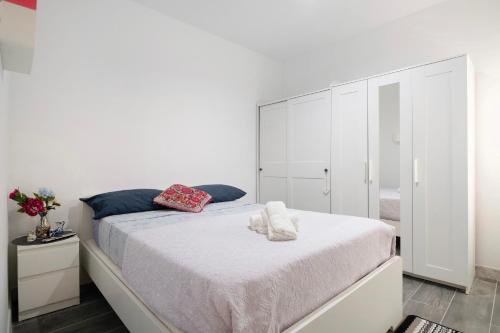 a white bedroom with a bed and a mirror at Piso Leon y Castillo in Arrecife