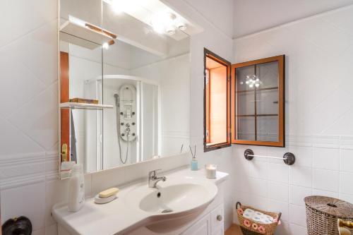a white bathroom with a sink and a mirror at Retiro Canario in Santa Brígida