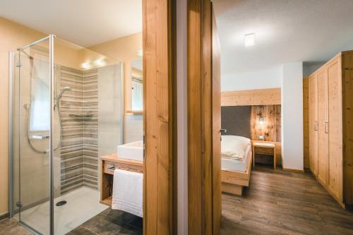 a bathroom with a shower and a bedroom at Chalet La Flüta Margherita in La Valle