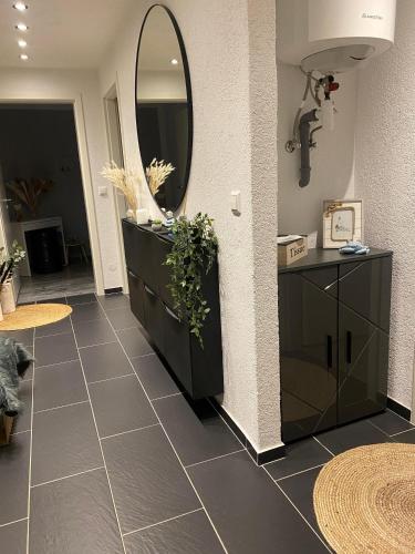 a bathroom with a black vanity and a mirror at Fewo Lago di Costanza I in Friedrichshafen