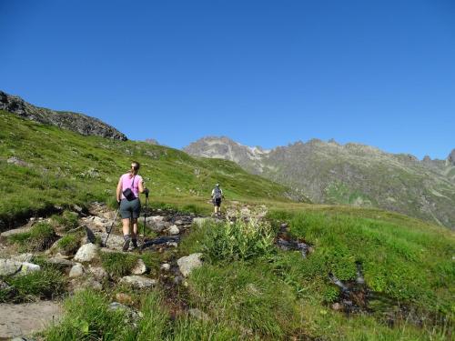two people walking up a hill on a trail at Aktiv-Ferienwohnungen Montafon in Sankt Gallenkirch