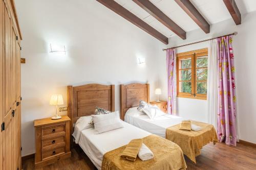 a bedroom with two beds and two tables in it at Son Pou in Sencelles
