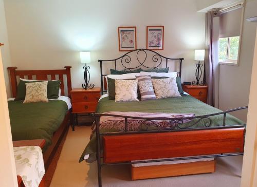 a bedroom with two beds and two night stands at Oaktree Guest House in Narbethong
