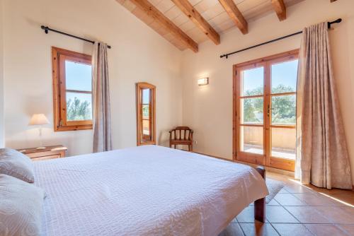 a bedroom with a bed and a large window at Son Forte Nou in Artá