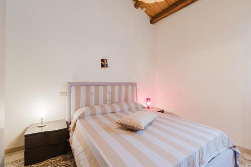a bedroom with a bed with a striped blanket at Da Giovanni A Custonaci in Custonaci