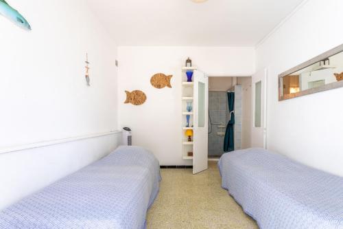 a bedroom with two beds and a mirror at Villa de la brune in Bormes-les-Mimosas