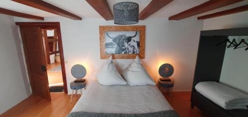 a bedroom with a bed with a picture on the wall at Schatzkästchen am Bodensee in Öhningen