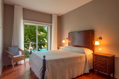 a bedroom with a bed and a window and a chair at Afife Sea and Mountain Retreat in Afife