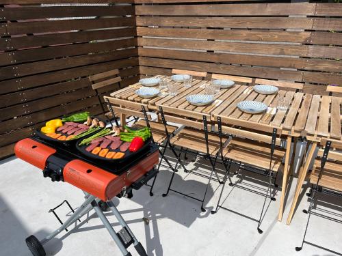 a grill with food on it next to a table at 伊勢ブルーヴィラ本館と離れ in Ise