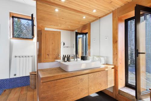 a bathroom with a white sink and a window at Casa Do Alto Da Coutada in Ponte de Lima