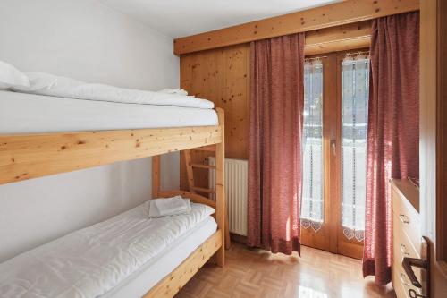 a bedroom with two bunk beds and a window at Ciasa Lino Rotic in Gardeccia - San Giovanni di Fassa