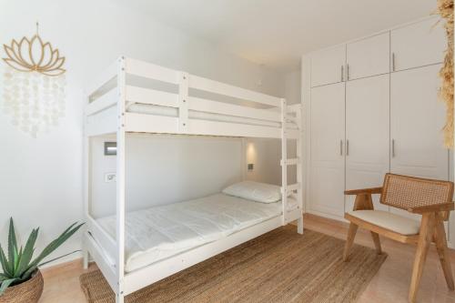 a white bunk bed in a room with a chair at Coco Canaria in Corralejo