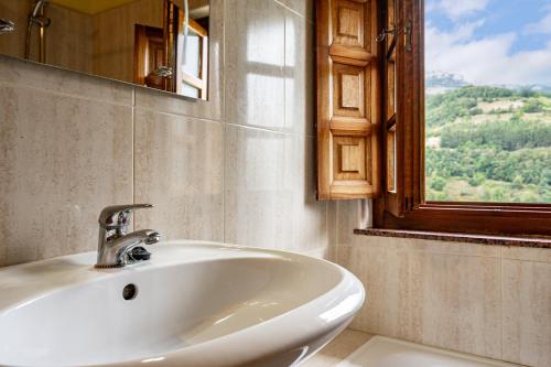 ein Badezimmer mit Waschbecken, Spiegel und Fenster in der Unterkunft Socastillo A in Fresnedo