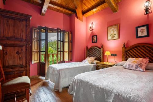 zwei Betten in einem Zimmer mit rosa Wänden in der Unterkunft Socastillo A in Fresnedo