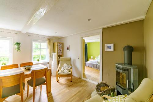 a living room with a fireplace and a bedroom at Rosen Hus in Pellworm