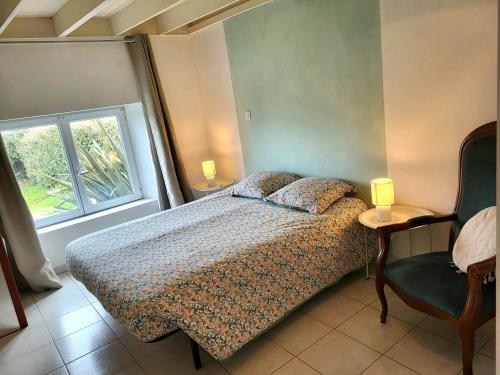 a bedroom with a bed and a window and a chair at La Maison Du Rivage in Bretteville-sur-Ay