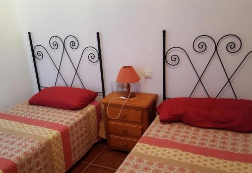 a bedroom with two beds and a table with a lamp at Beach apartment in Los Cristianos in Los Cristianos