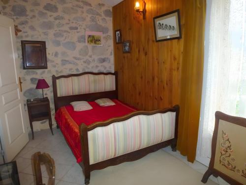 a small bedroom with a bed with a red blanket at Gîte Paysan La Grange in Montrond