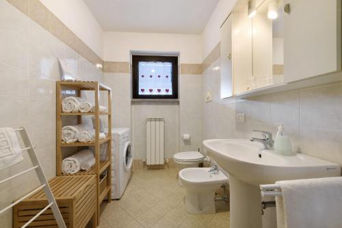 a white bathroom with a sink and a toilet at Como's Lake Mountains beb in Cremeno