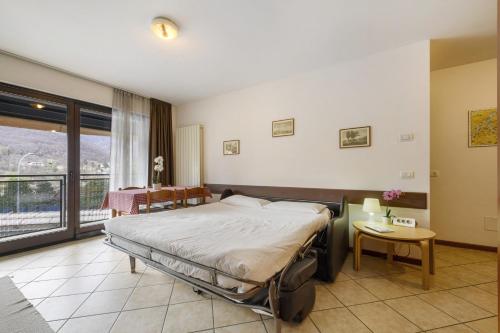 a bedroom with a bed and a table and a window at Como's Lake Mountains beb in Cremeno