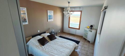 a small bedroom with a bed and a window at Appartement T2 face à la mer in Saint-Vaast-la-Hougue